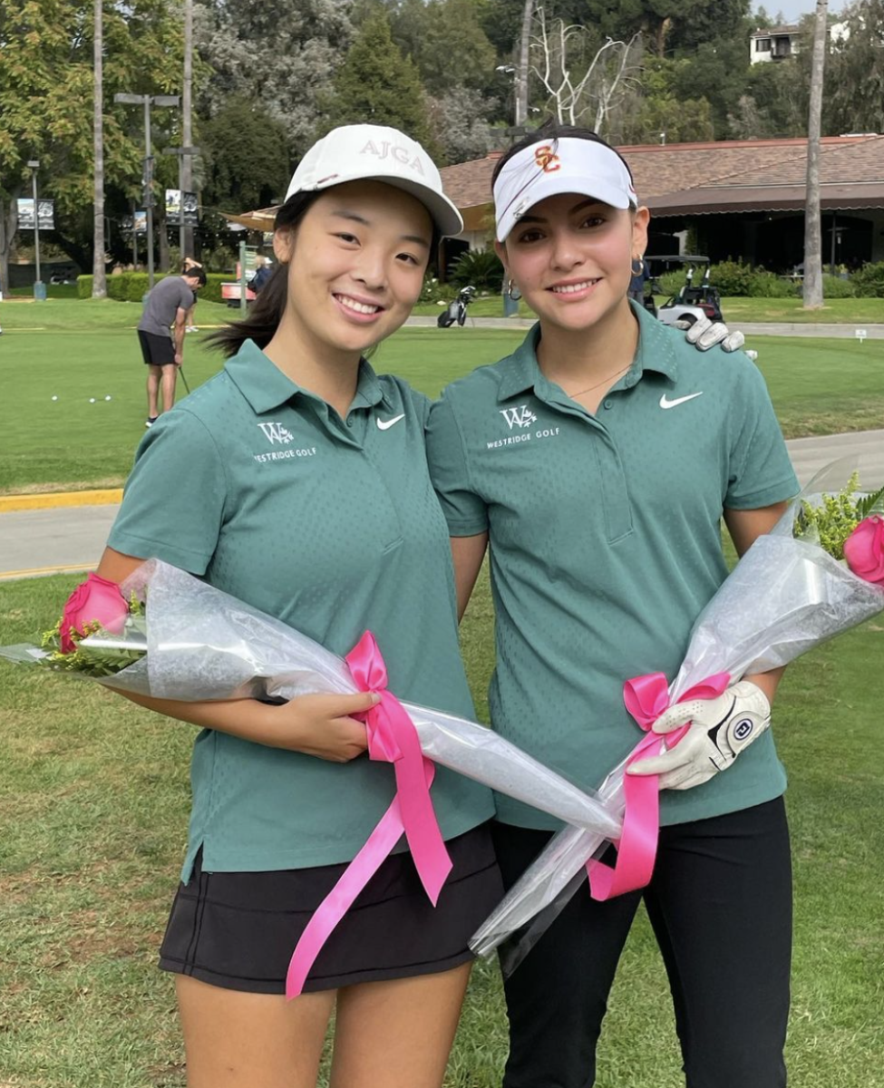 Claudia Z. (left) and Kayla A. (right) hold roses as they are celebrated for their contributions to the team on Senior Night.